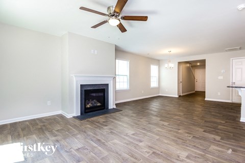 the living room has a fireplace and hardwood floors