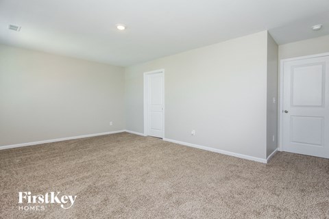 a bedroom with white walls and carpet and white doors