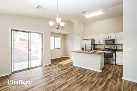 A kitchen with a wooden floor and white walls.