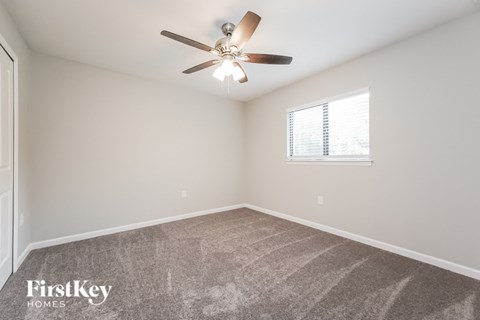 a bedroom with a ceiling fan and a window