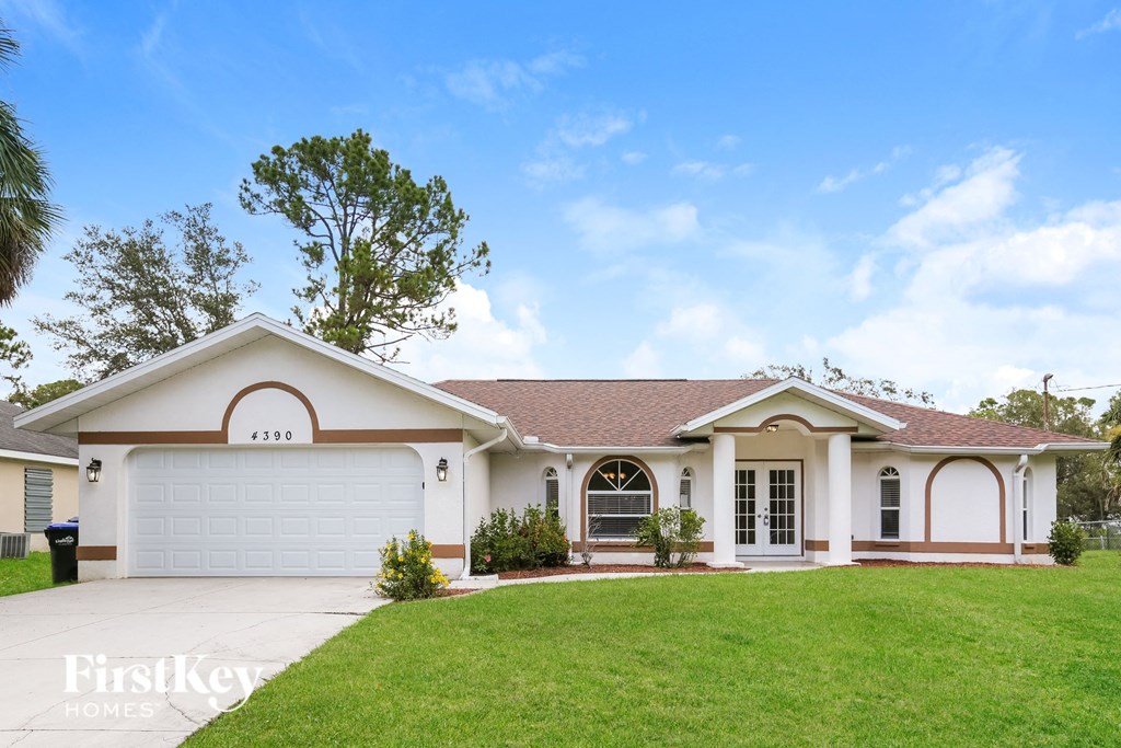 A house with a brown trim and a white garage door is for sale.