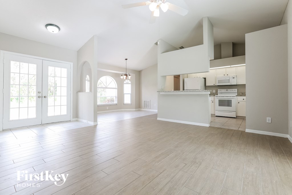 A spacious kitchen with a white countertop and a ceiling fan.