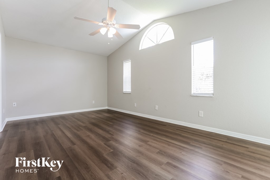 A room with wooden flooring and a ceiling fan.