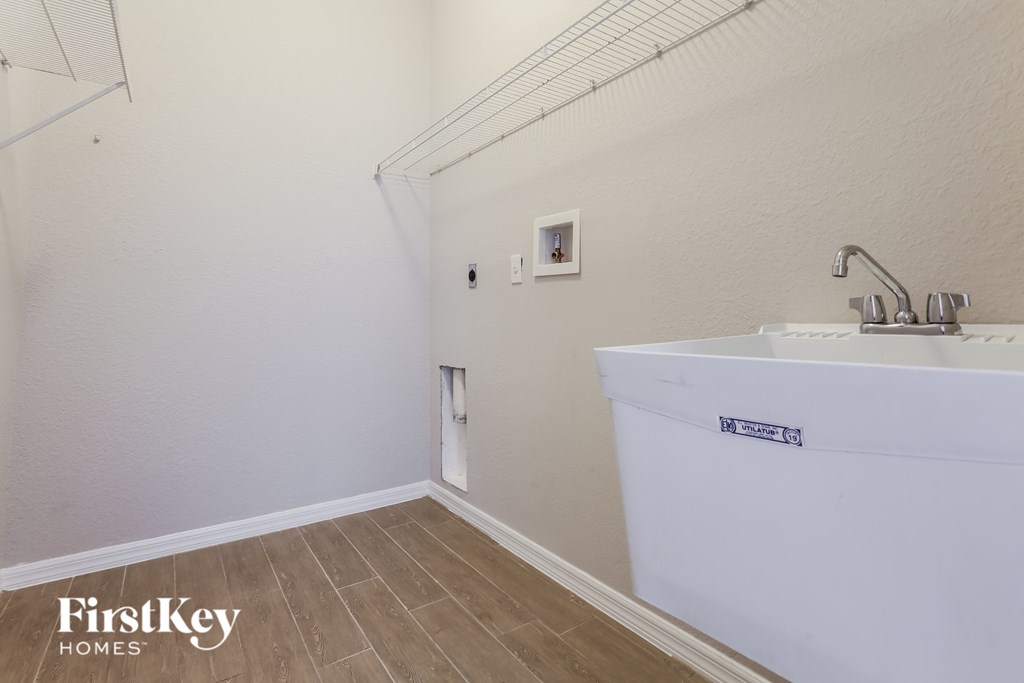 A white bathroom sink with a FirstKey Homes logo on the side.