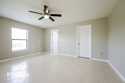 A spacious room with a ceiling fan and tile flooring.