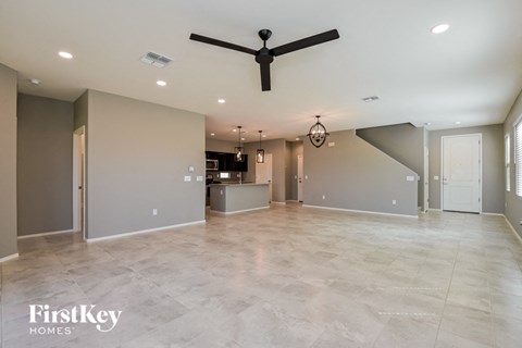A spacious room with a ceiling fan and a chandelier.