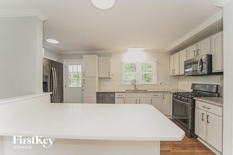 a white kitchen with a large white counter top