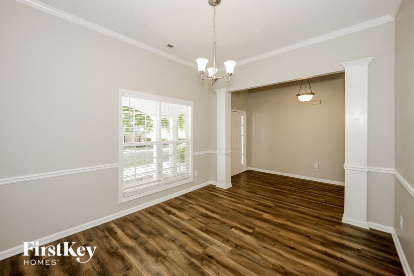 an empty living room with wood flooring and a window