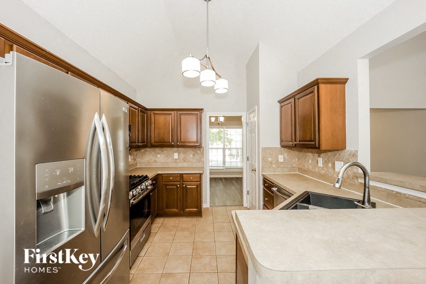 a kitchen with a stainless steel refrigerator and a sink