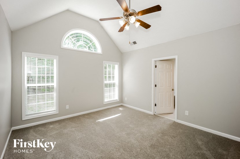 an empty room with a ceiling fan and a door