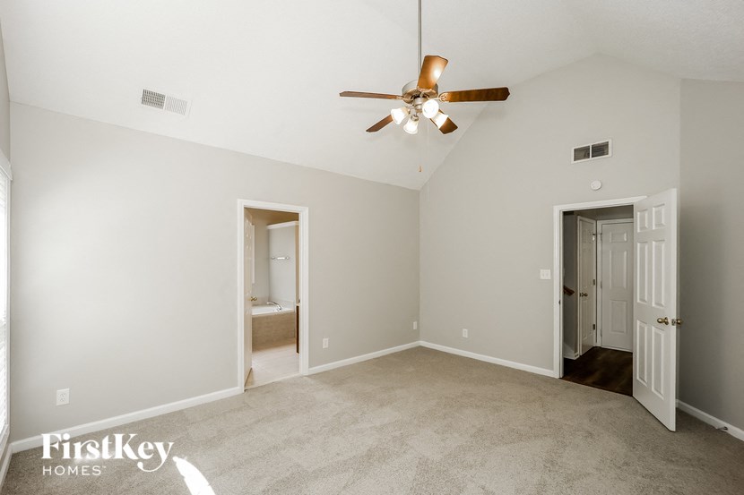 an empty living room with a ceiling fan