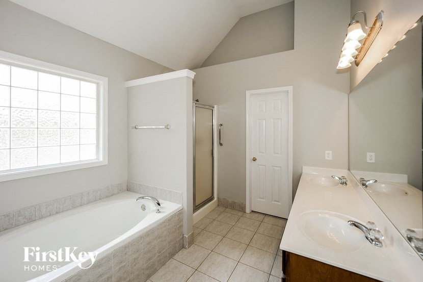a bathroom with a tub and a sink and a mirror