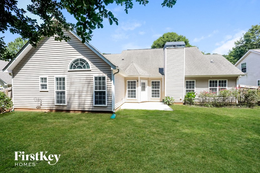 a white house with a gray roof and a yard