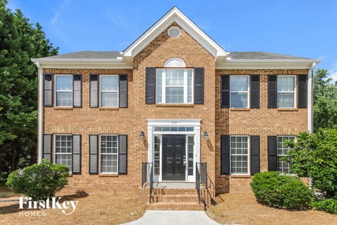 a brick house with black shutters and a black front door