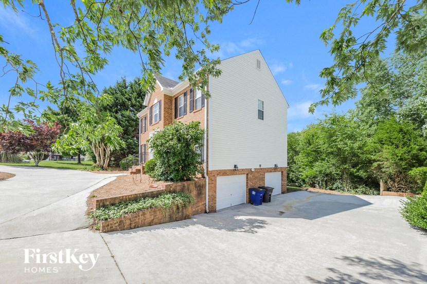 a white and brick house with a garage and a driveway