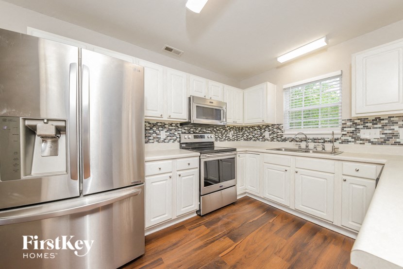 a kitchen with white cabinets and stainless steel appliances