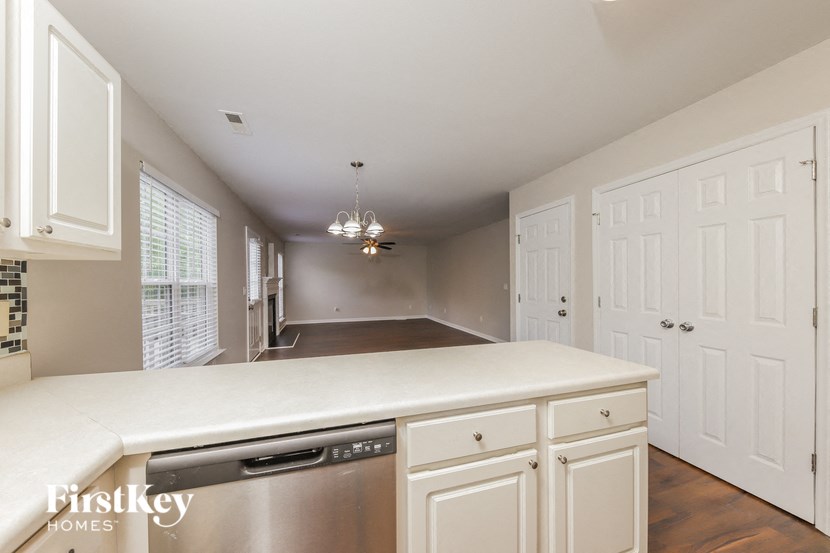 an empty kitchen with white cabinets and a stainless steel dishwasher