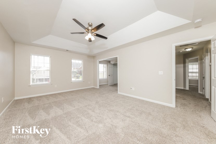 an empty living room with a ceiling fan