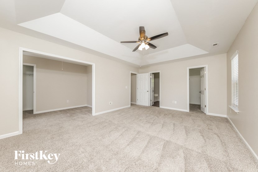 an empty living room with a ceiling fan