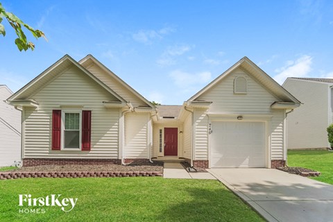 a white house with a red front door and a lawn