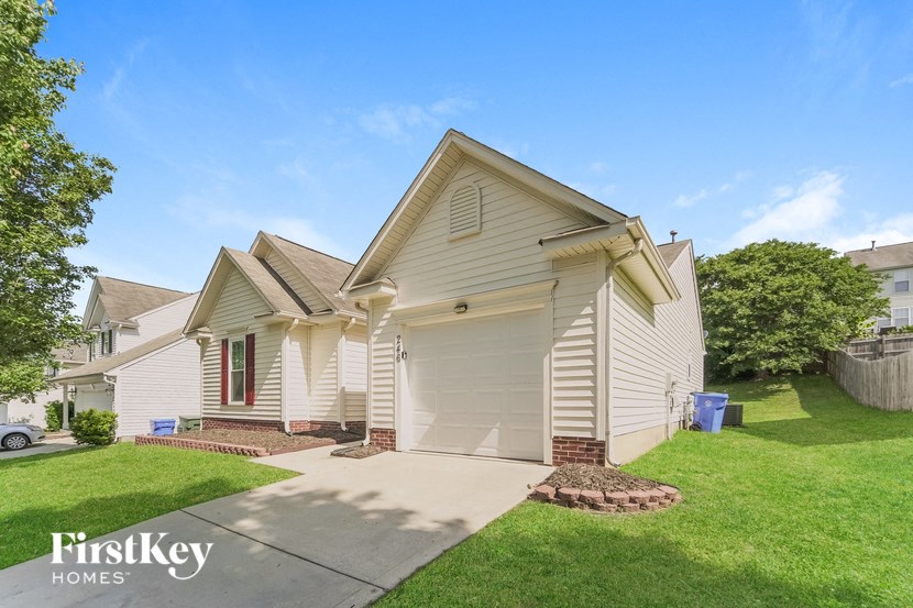 a white house with a driveway and a lawn