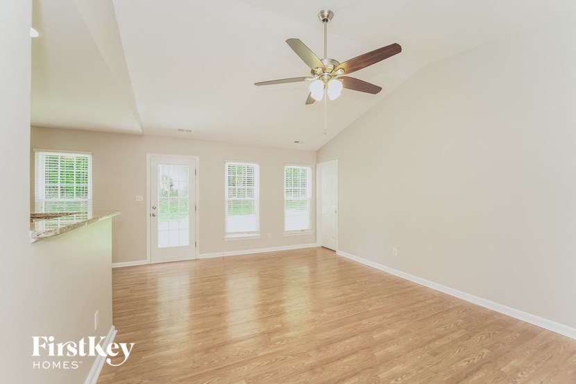 an empty living room with a ceiling fan