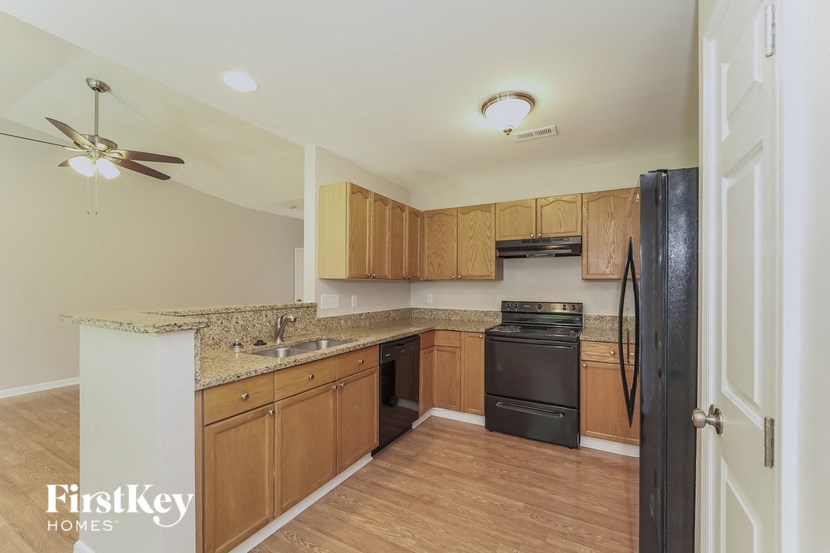 a kitchen with wooden cabinets and a black refrigerator