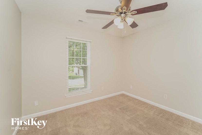 a empty room with a ceiling fan and a window