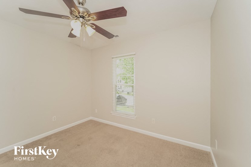 a bedroom with a ceiling fan and a window