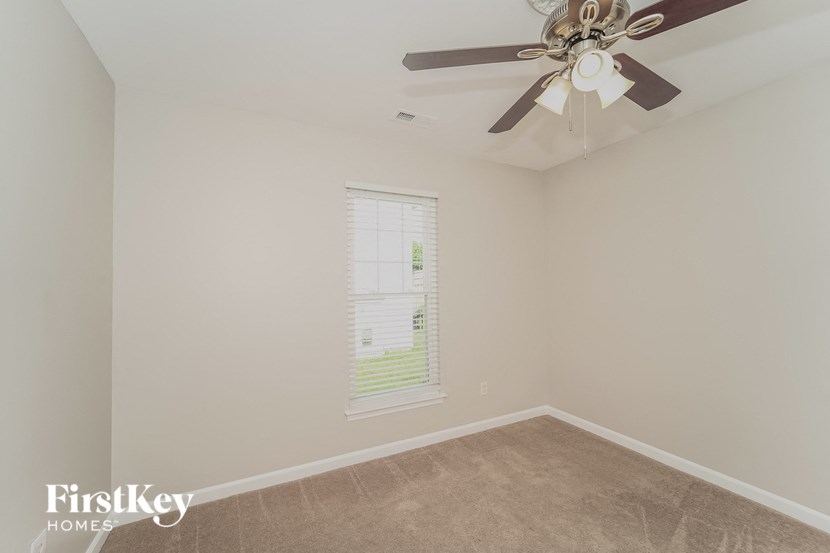 a bedroom with a ceiling fan and a window