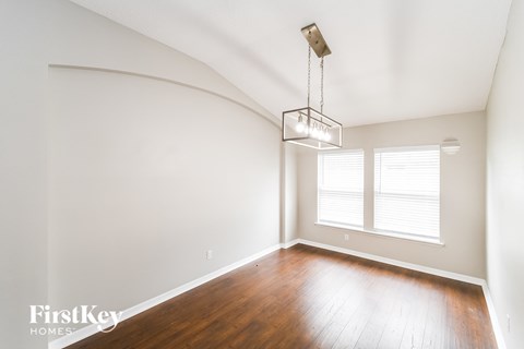 A room with wooden floors and a light hanging from the ceiling.