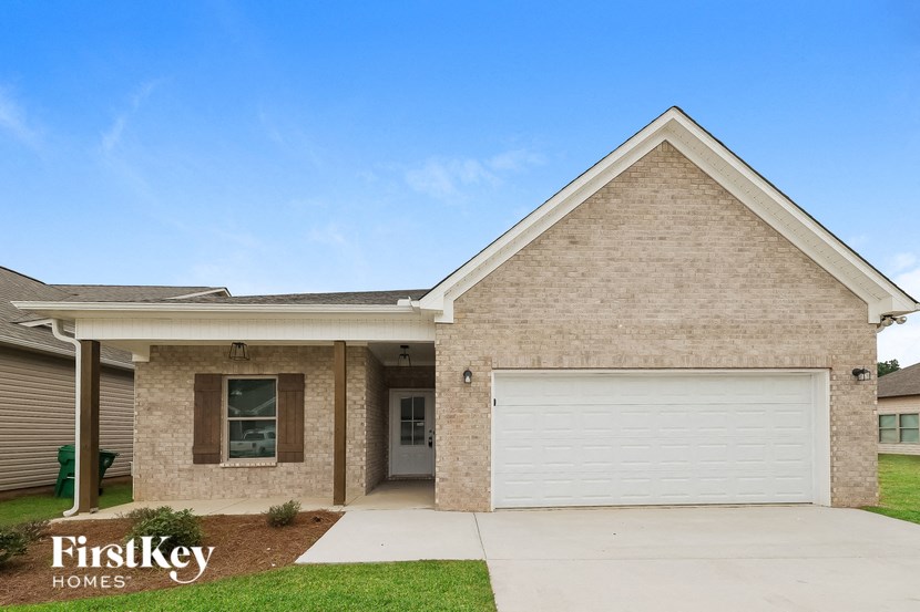 A house with a garage door and a window is for sale by FirstKey Homes.