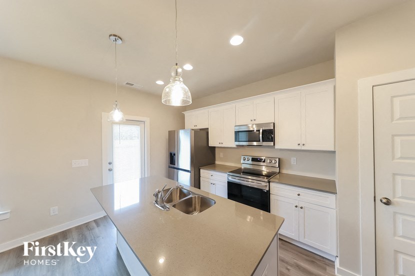 A kitchen with a stove top oven and a refrigerator.