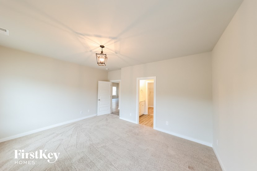 A large empty room with a light hanging from the ceiling.