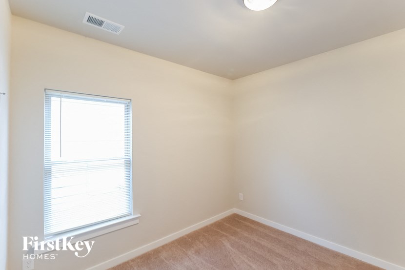 A room with a window and a wooden floor.