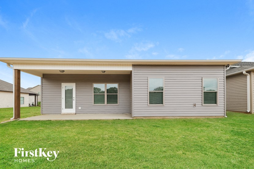 A house with a grey siding and a white door is shown.