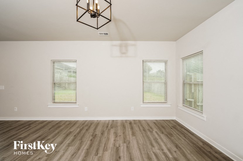 the living room of a home with wood floors and a chandelier