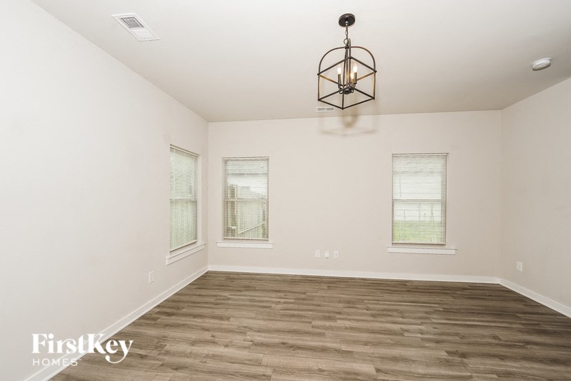 a empty living room with wood floors and a chandelier