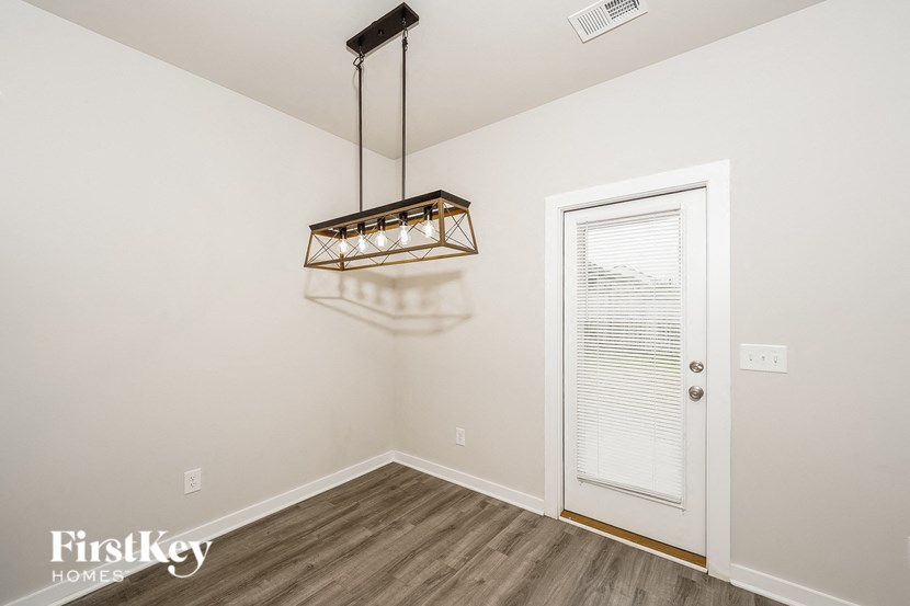 the living room of a home with a door and a chandelier