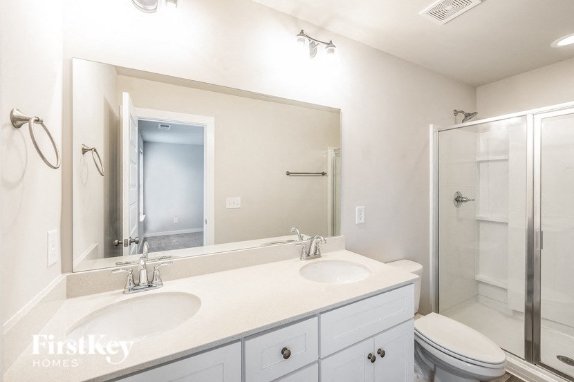 a white bathroom with two sinks and a shower