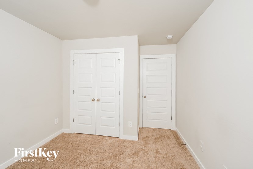 a bedroom with two closets and a carpeted floor