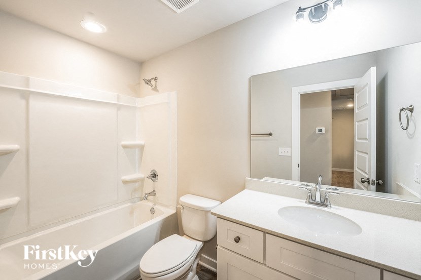 a bathroom with a sink toilet and a mirror