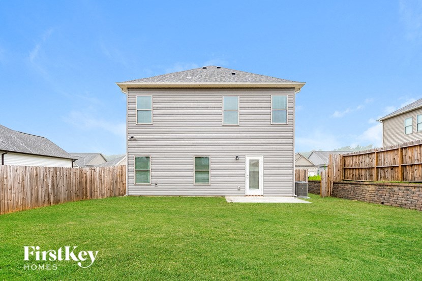 the back of a house in a fenced in backyard