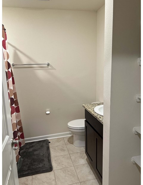 a bathroom with a toilet and a shower and a sink