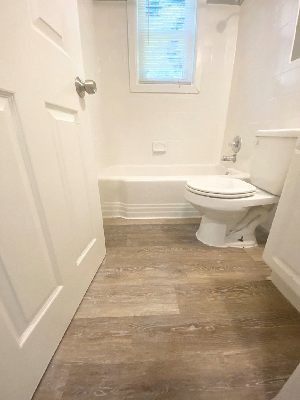 a small bathroom with a toilet and a tub and a window