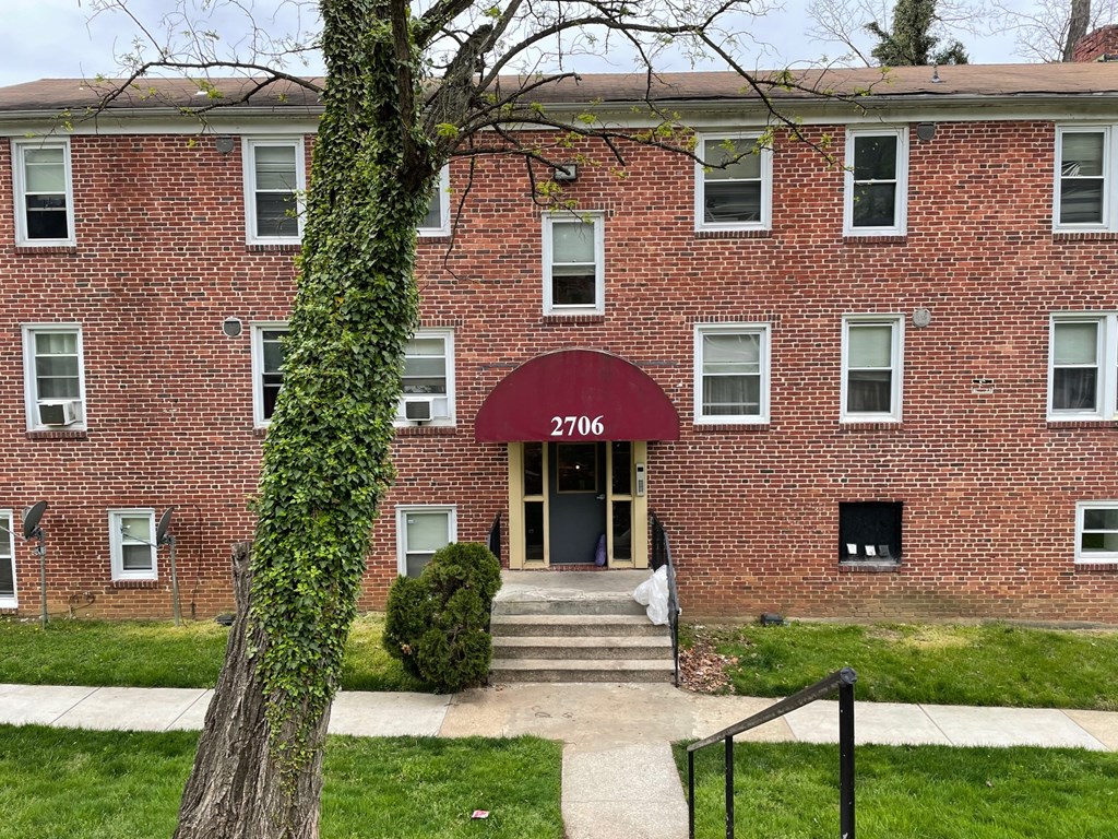 a red brick building with a tree in front of it
