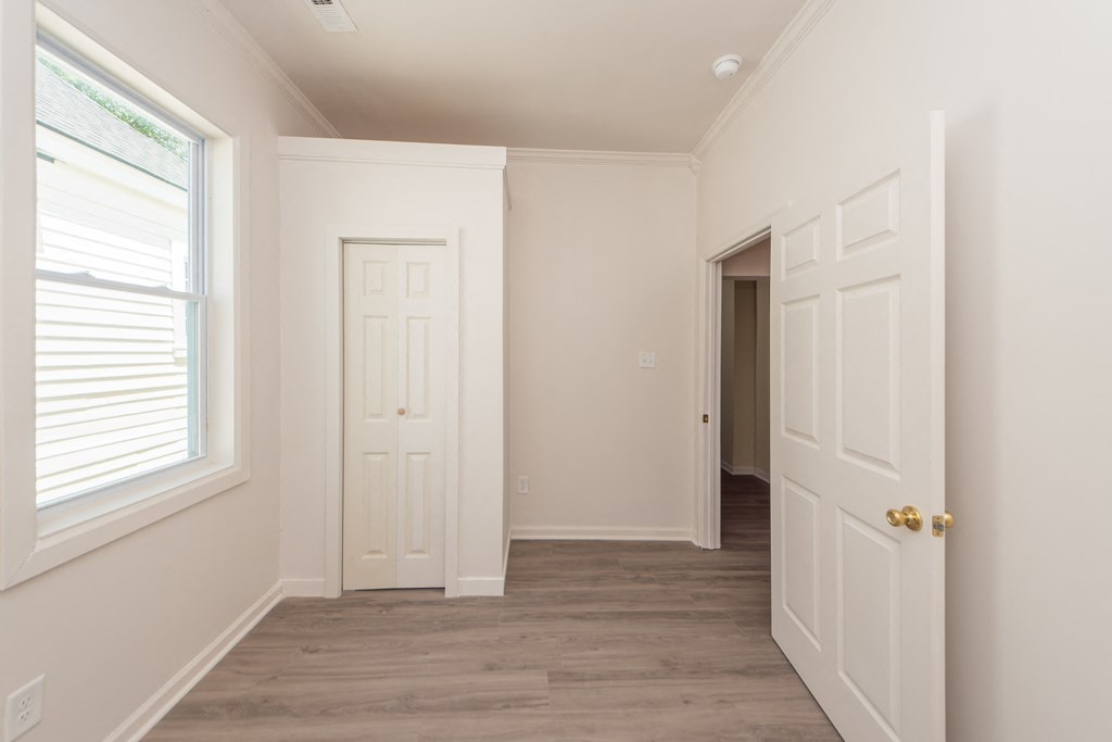 an empty room with white walls and a door and a window