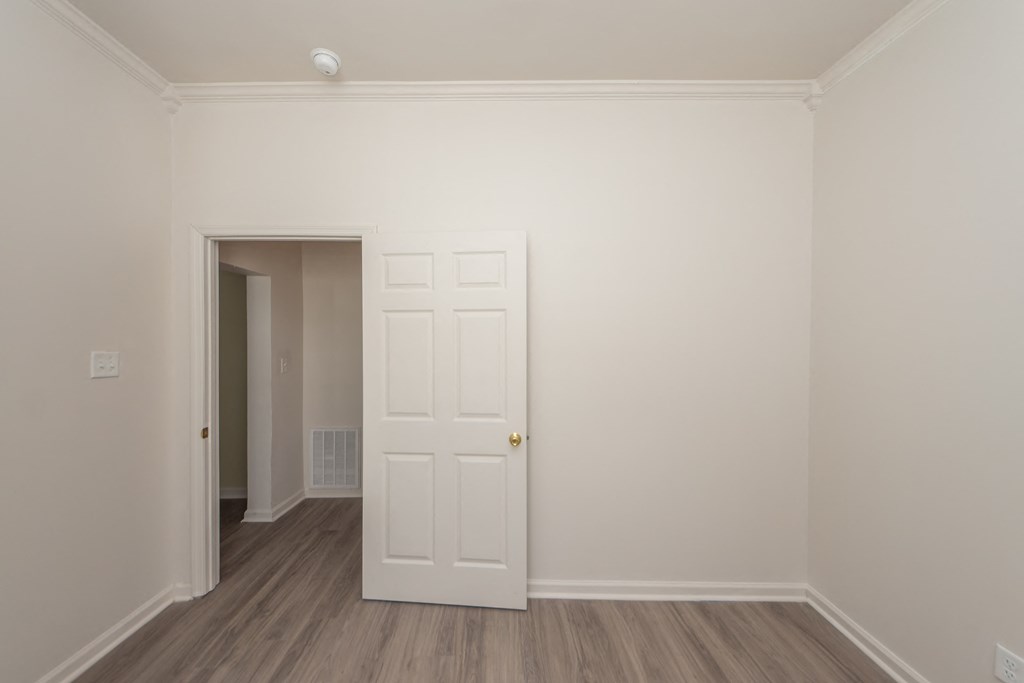 a bedroom with a white door and a door to a hallway