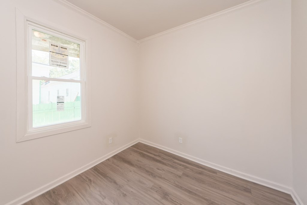 an empty room with white walls and a window