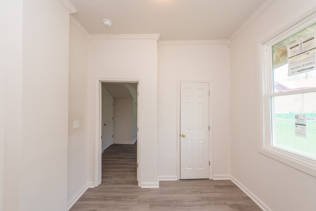 an empty room with white walls and a door and a window
